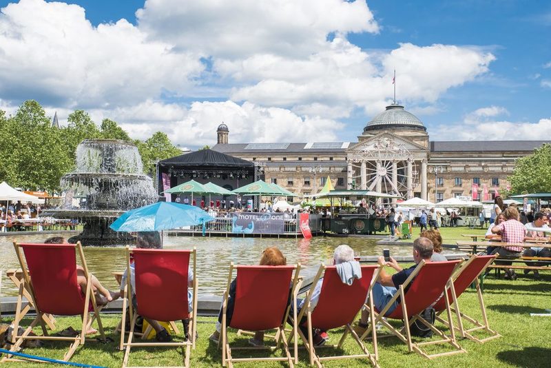 Menschen in den Liegestühlen vor dem Kurhaus